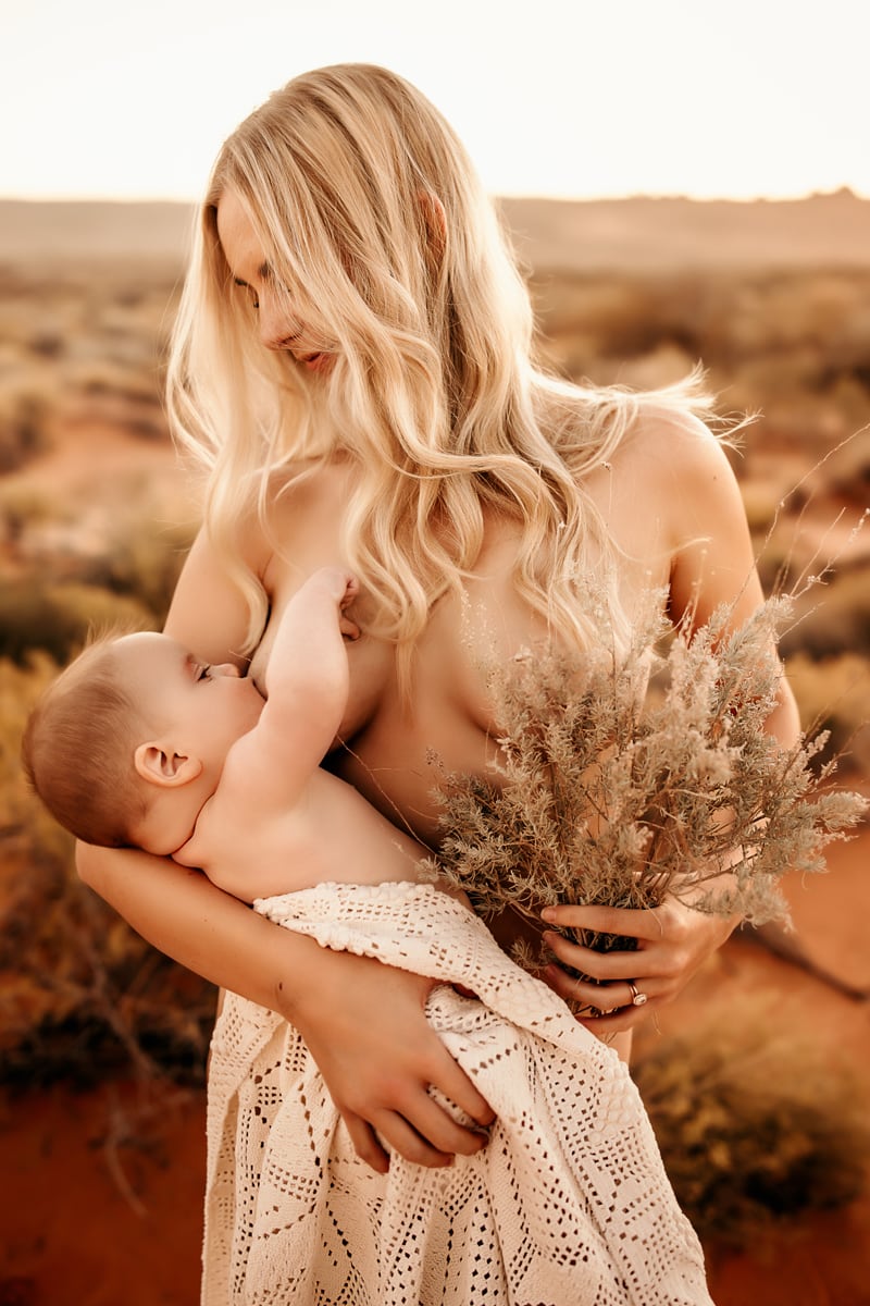 Motherhood Photographer, mother breastfeeds baby in the wild