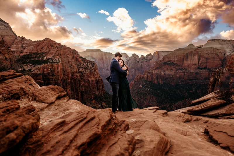 Vacation Photographer, a couple embrace each other closely on the high canyon walls on Zion