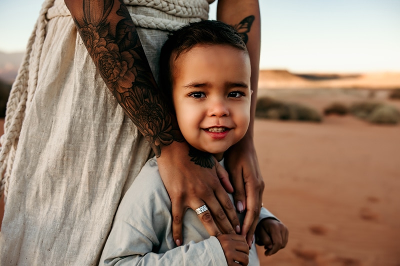 Motherhood Photographer, mom's arms embrace her young son, he smiles