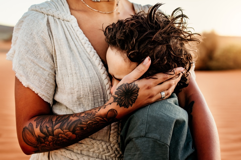 Motherhood Photographer, a mother holds her young son close to her softly