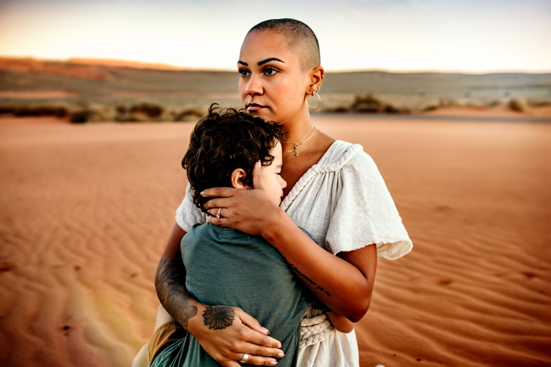 Motherhood Photographer, mother hugs her young son in the desert sands