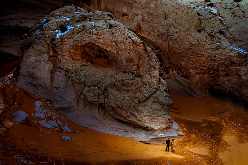 Vacation Photographer, a man and woman stand dwarfed inside the high canyon walls