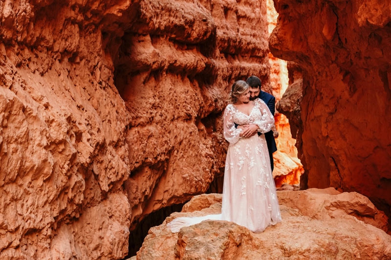 Elopement Photographer,  A bride and groom hold each near Bryce Canyon's walls