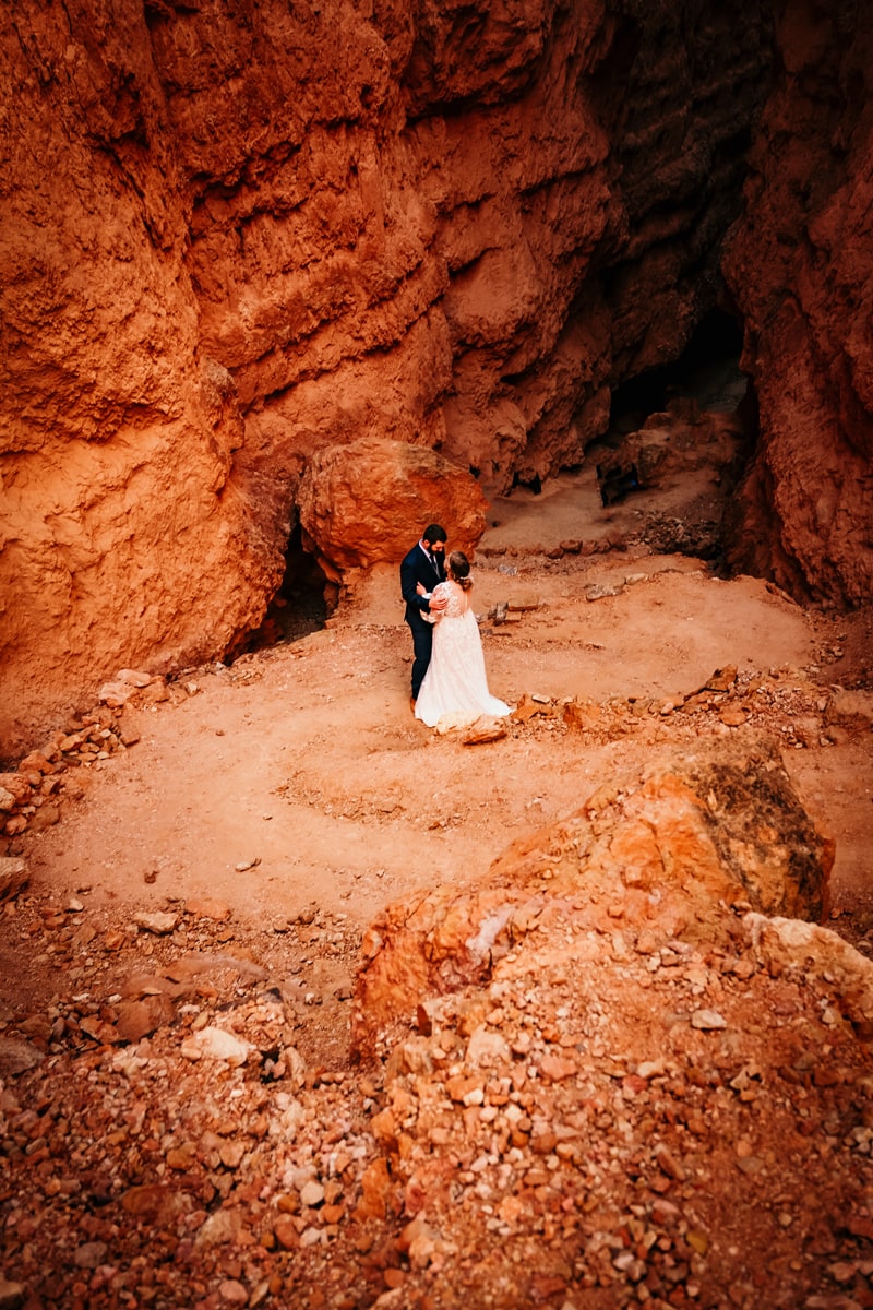 Elopement Photographer, a newly married couple hold each other beneath Bryce Canyon walls