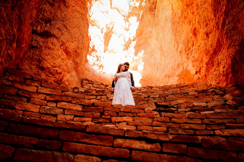 Elopement Photographer, a new husband and wife hold each other on the stone steps in Bryce Canyon