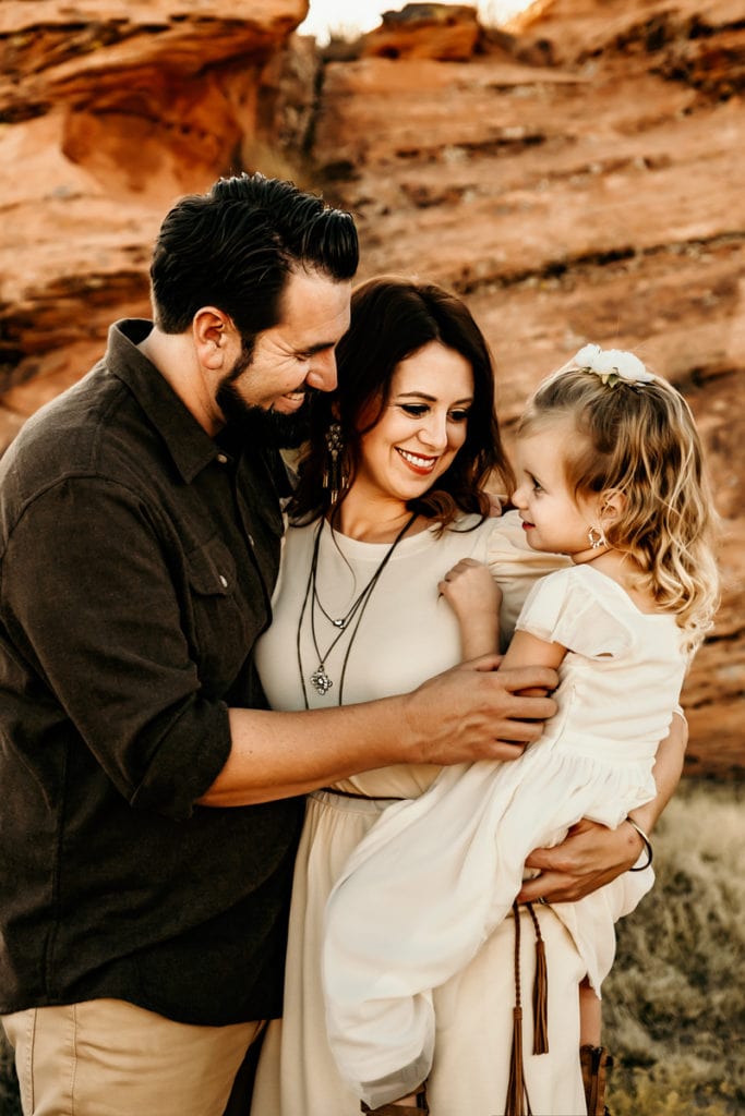 Family Photographer, Mom and dad admire they toddler daughter outdoors in nature