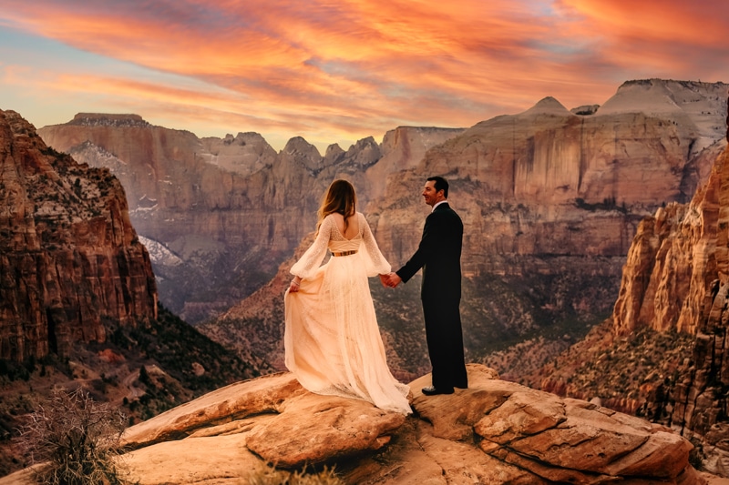 Elopement Photographer, newly eloped husband and wife hold hands at sunset in ZIon