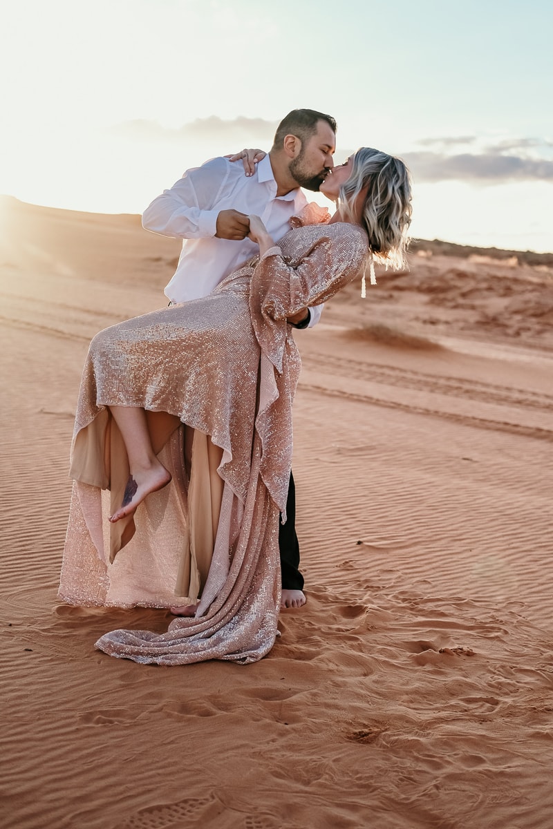 Elopement Photographer, a couple kiss as the husband dips his wife in the Utah sands