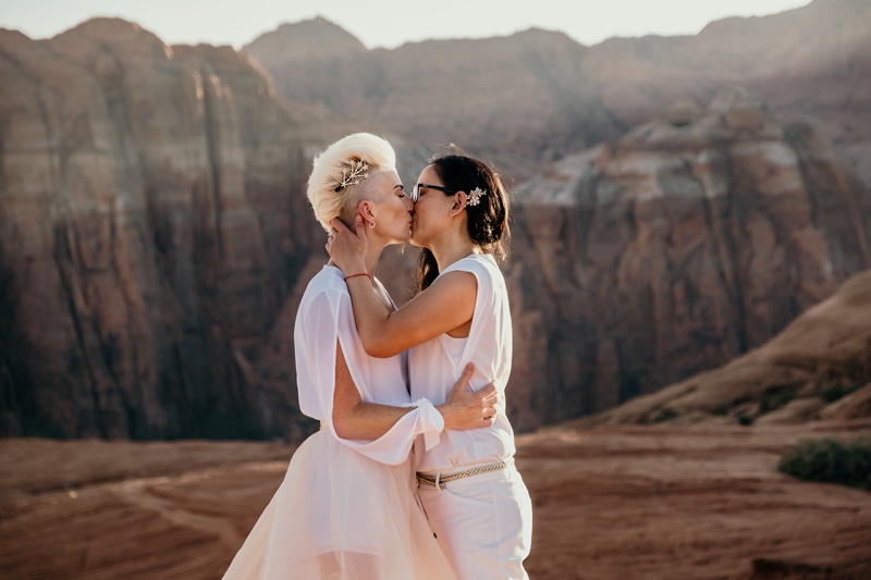 Elopement Photographer, two newly married brides kiss before Utah landscape