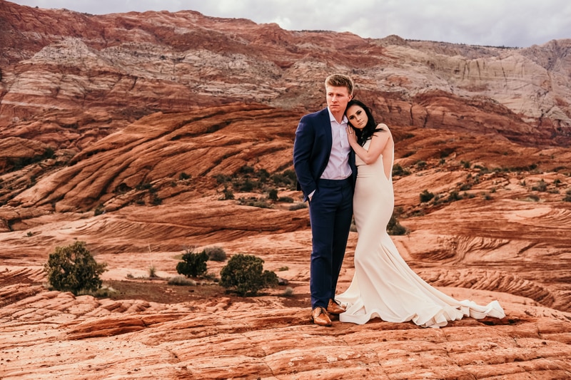 Elopement Photographer,  bride leans on grooms shoulders as they stand in Utah wilderness