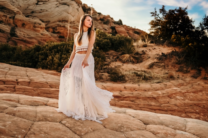Elopement Photographer, A bride stands alone in desert sandstone landscape