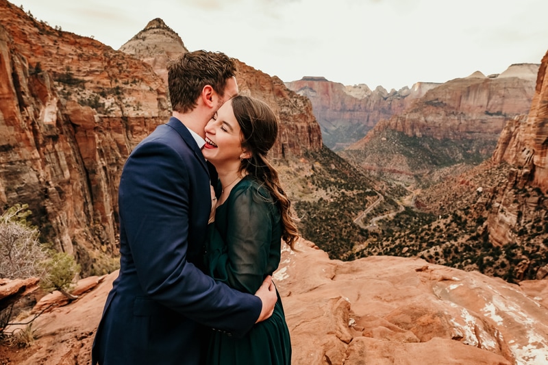 Vacation Photographer, a couple laugh and embrace before Utah's Zion National Park