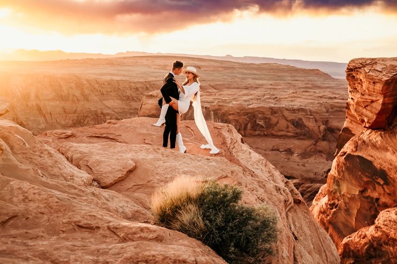 Elopement Photographer, a new husband and wife hold each other atop utah canyons