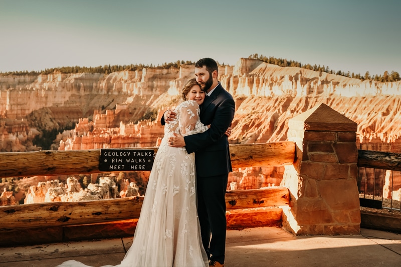 Elopement Photographer, newly married couple hug on ledge in Bryce National Park