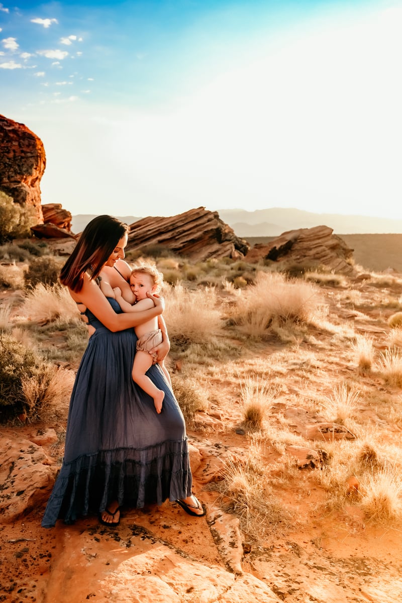 Motherhood Photographer, mother breastfeeds child in the desert